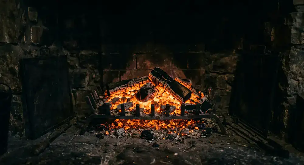 Glowing orange embers in a dark hearth